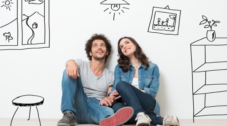 young couple daydreaming with cartoon images of new home