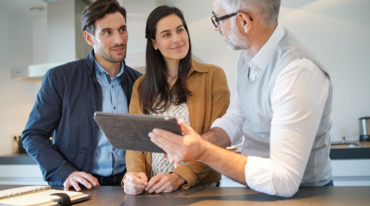man explaining 3d planning with tablet to young couple