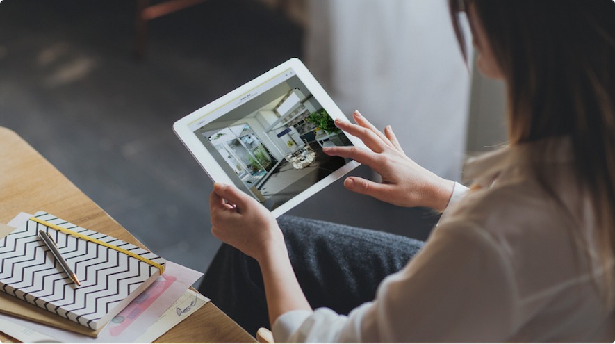 A woman using HomeByme on her tablet. She is taking a realistic image