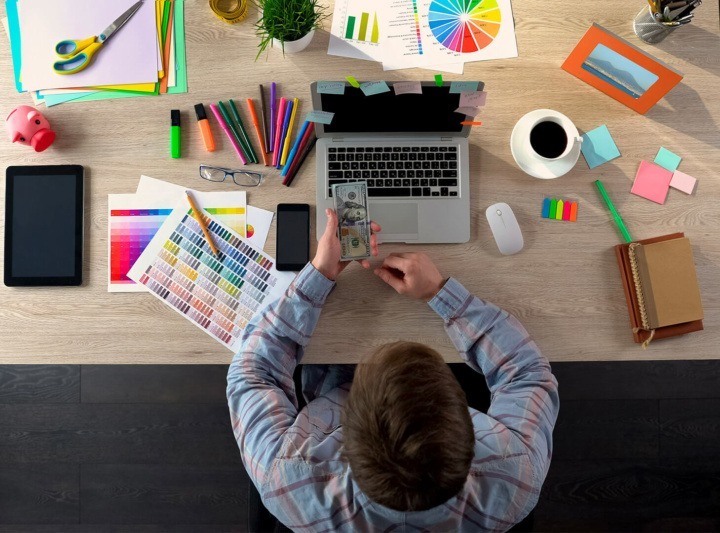 Interior designer with some cash working at his desk