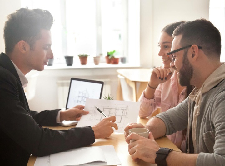 A professional pitching a project to two clients