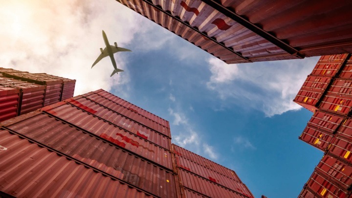 A plane flies over a container storage site